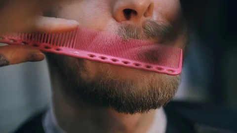 Young handsome bearded man getting a haircut in a modern barber shop. Видео 86477869
