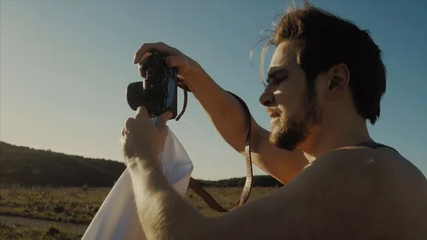 Young handsome bearded man making photos with his camera. Stock Footage 129501789