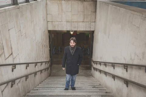 Young handsome bearded man posing on stairs Stock Photos