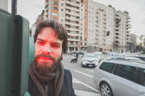 Young handsome bearded man posing in the city streets Stock Photos