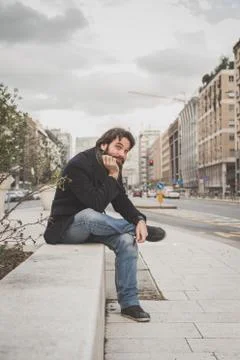 Young handsome bearded man posing in the city streets Stock Photos