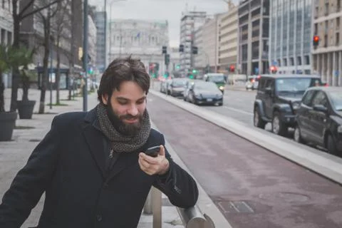 Young handsome bearded man posing in the city streets Stock Photos