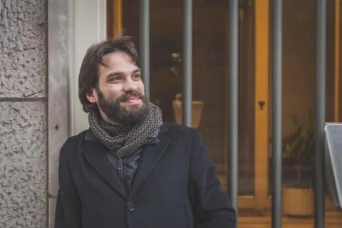 Young handsome bearded man posing in the city streets Stock Photos