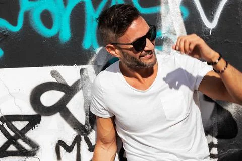 A young handsome bearded man posing in an urban background Stock Photos