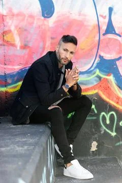 A young handsome bearded man posing in an urban background Stock Photos