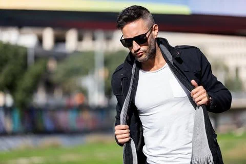 A young handsome bearded man posing in an urban background Stock Photos