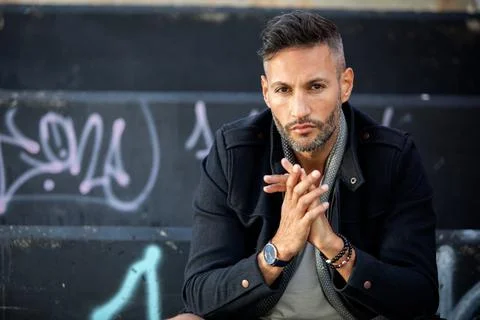 A young handsome bearded man posing in an urban background Stock Photos