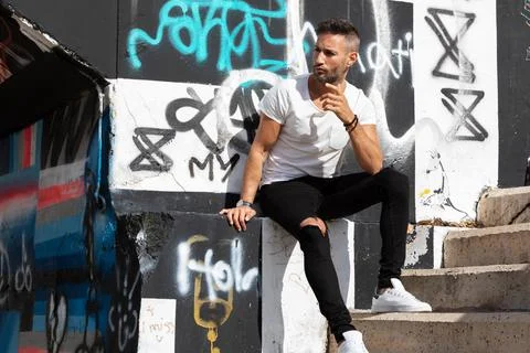 A young handsome bearded man posing in an urban background Stock Photos