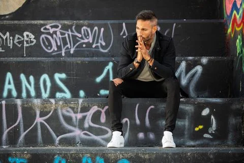 A young handsome bearded man posing in an urban background Stock Photos