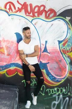 A young handsome bearded man posing in an urban background Stock Photos