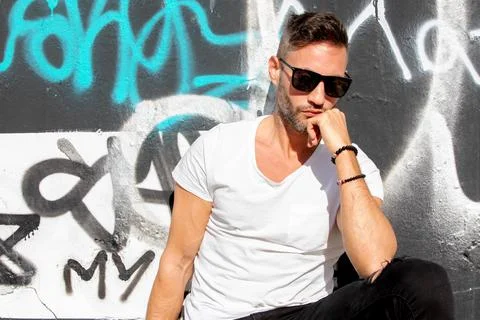 A young handsome bearded man posing in an urban background Stock Photos