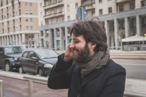 Young handsome bearded man talking on phone Stock Photos