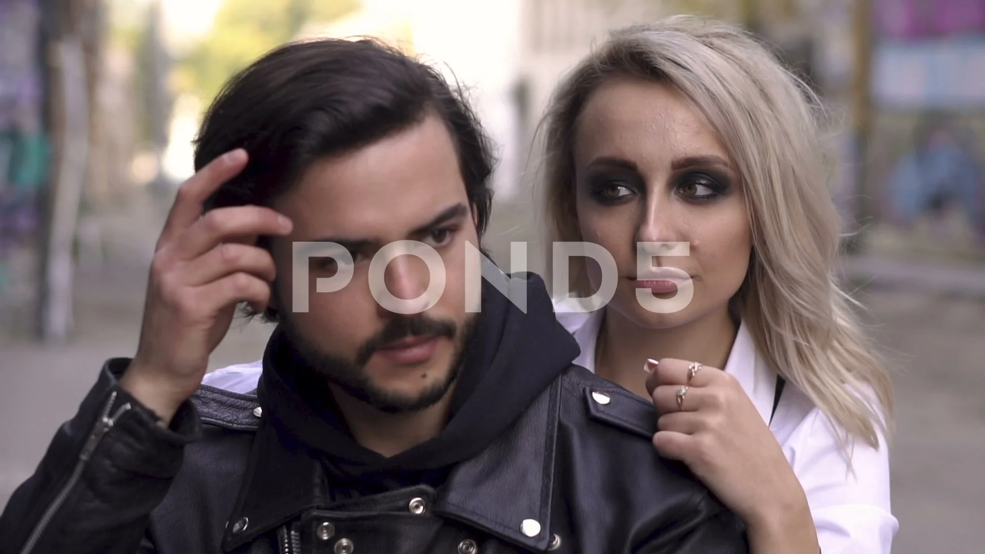 Young handsome biker guy in helmet and attractive blonde girl with smokey  eyes