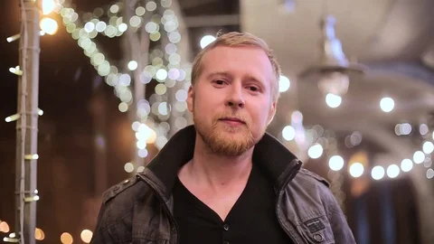 A young handsome blond man looking at the camera against city background Stock-Footage 75045679