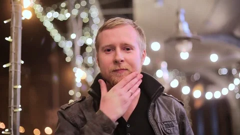 A young handsome blond man looking at the camera against city background Stock-Footage 75045742