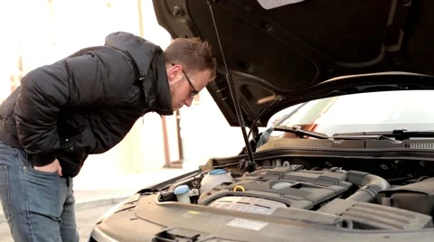 Young handsome boy in black jacket and glasses, standing behind his car Video stock 49338228