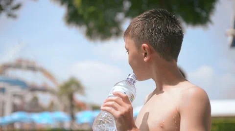 Young handsome boy drinks water luxuriating in the sun Stock Footage 51879376
