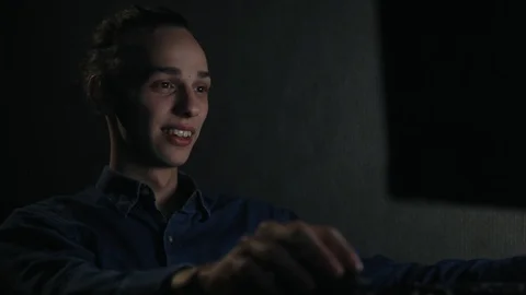 Young handsome boy laughing in front of computer at night, close up 動画素材 99051216
