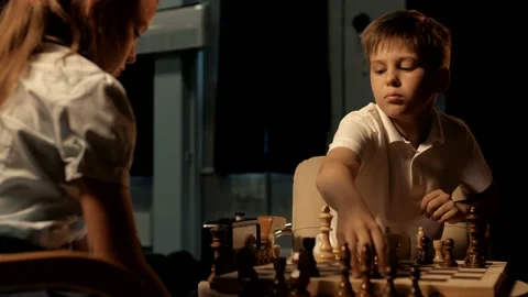 Young handsome boy makes a move with his knight during a chess game Stock Footage 156707391