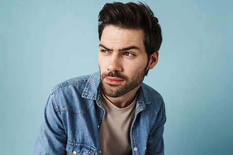Young handsome brooding guy thinking and looking aside Stock Photos