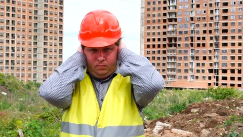 Young handsome builder is afraid (man covers his ears with hands) - construction Stock-Footage 111872660