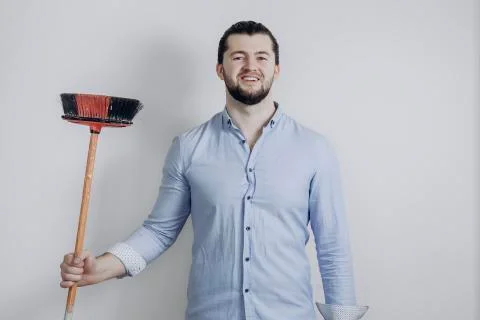 Young handsome businessman with cleaning broom on Gray backgroung Stock Photos