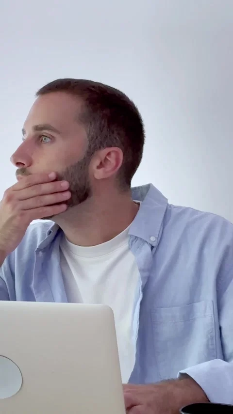 Young handsome businessman thinking while working on his laptop, looking away Video stock 346839590