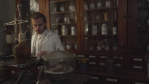 Young handsome Caucasian man checking medicines in ancient pharmacy when older Stock Footage 120722070