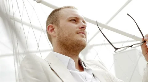 Young handsome caucasian man taking of glasses. white casual suit Video stock 42948100