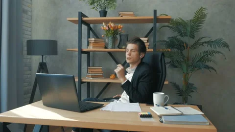 A young handsome ceo conducts a meeting with subordinates via video link. A Stock Footage 155384553