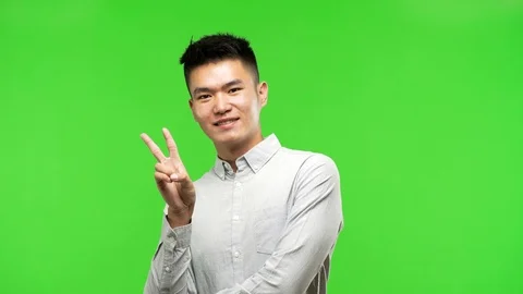 Young handsome chinese man doing a gesture of victory Stock Footage 97871702