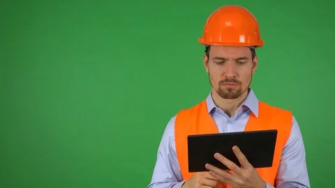 A young handsome construction worker works on a tablet - green screen studio Stock Footage 115081661