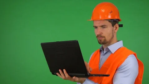 A young handsome construction worker works on a notebook - green screen studio Video stock 115081894