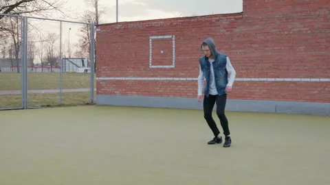 A young, handsome, energetic guy, a street dancer in black pants and a blue vest Vídeo Stock 108527488