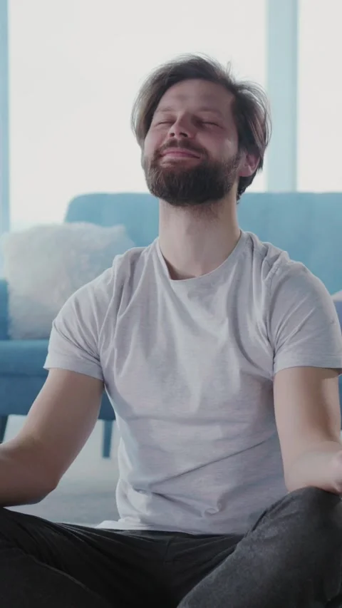 Young handsome funny man meditating yoga practice in smoked living room. His Stock Footage 313794874