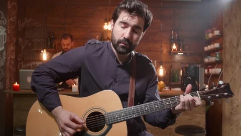 Young handsome guitar player performs a song in a bar Stock Footage 107387932