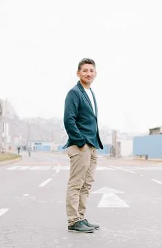 Young handsome guy with a beard walking on the city highway. Stock Photos