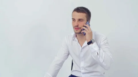 A young handsome guy flirts talking on the phone close up three quarters Video stock 83596992