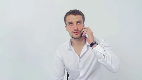 A young handsome guy flirts talking on the phone close up Video stock 83597359