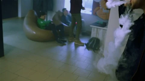 Young handsome guy lets rings out of steam Stock Footage 73027598