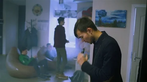 Young handsome guy lets rings out of steam Stock Footage 73027621