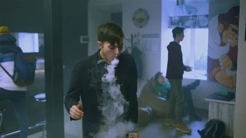 Young handsome guy lets rings out of steam Stock Footage 73027644