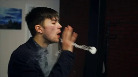 Young handsome guy lets rings out of steam Stock Footage 73027654