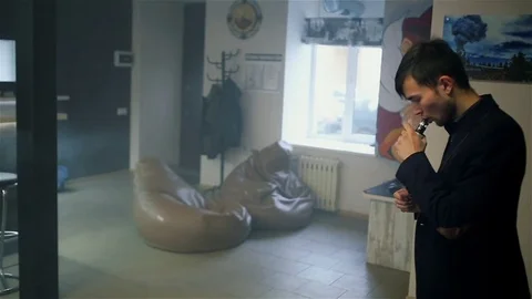 Young handsome guy lets rings out of steam Stock Footage 73027667