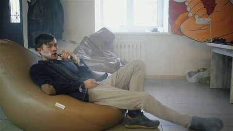 Young handsome guy lets rings out of steam Stock Footage 73027673