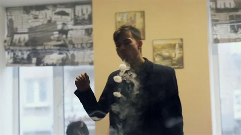 Young handsome guy lets rings out of steam Stock Footage 73027685