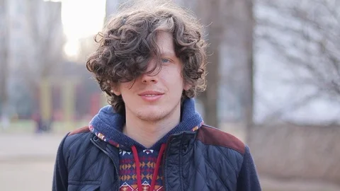 Young handsome guy looking at the camera and straightens his hair Video stock 125911276