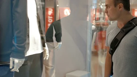 Young handsome guy looking at shop window. Shopping in the mall, sales time Stock Footage 76023163