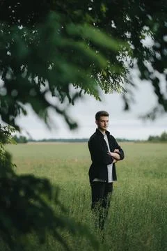 A young handsome guy with a small beard in a black shirt looks at the camera Stock Photos