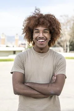 Young handsome guy smiling relaxed and looking at camera in the street with arms Stock Photos